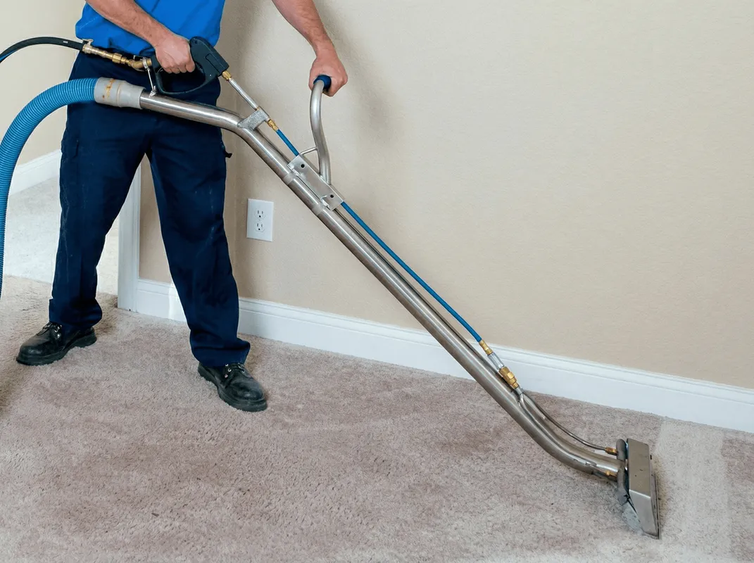 Professional operating a liquid removal machine on a carpeted floor in Toledo, OH
